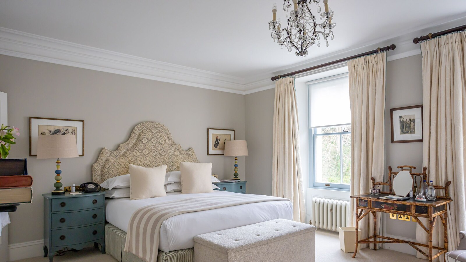 Beaverbrook — a country-house bedroom with a crystal chandelier and tall windows