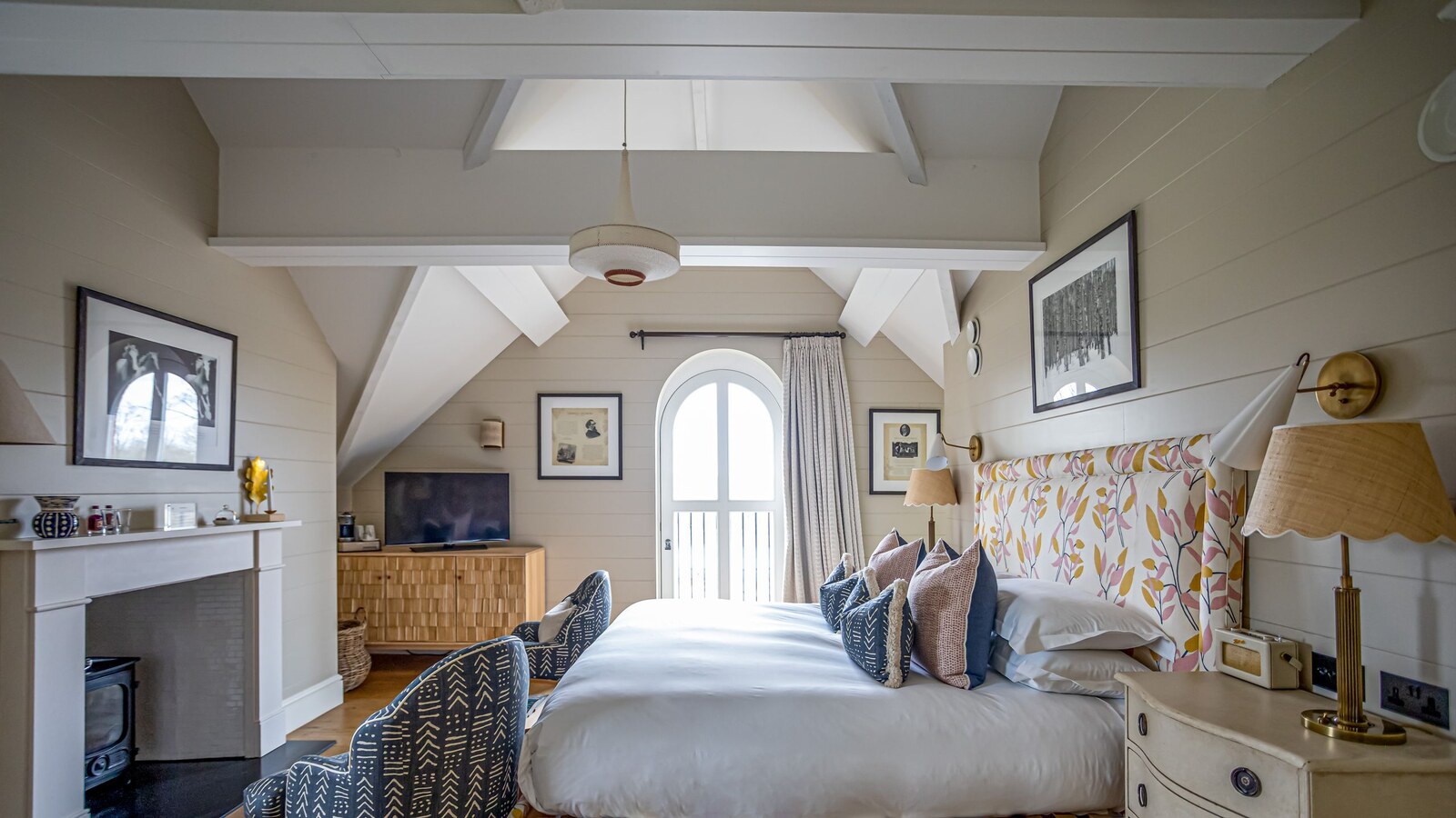 Beaverbrook — a beamed bedroom with a fireplace and arched garden door