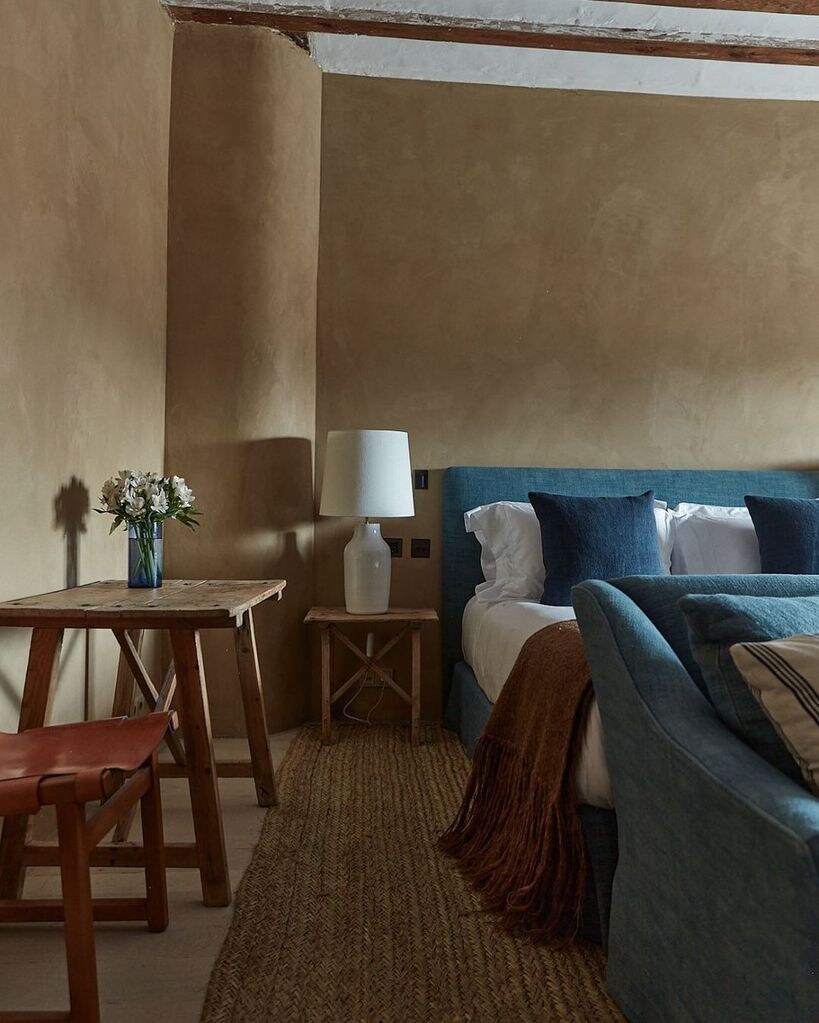 Casa Taberna — junior suite with ochre plaster walls and an indigo linen bed