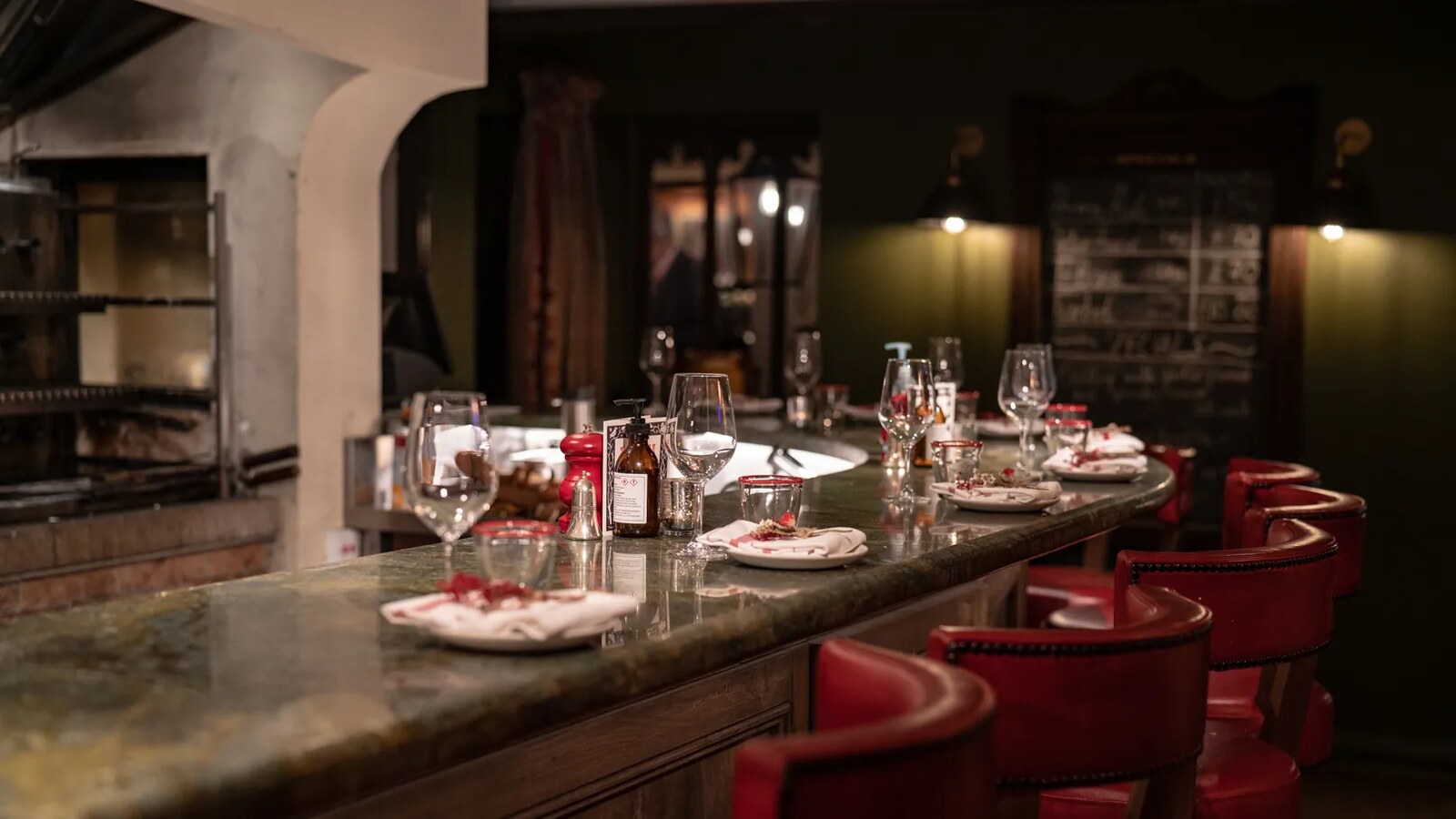 The Double Red Duke — the open-fire kitchen counter with red leather chairs
