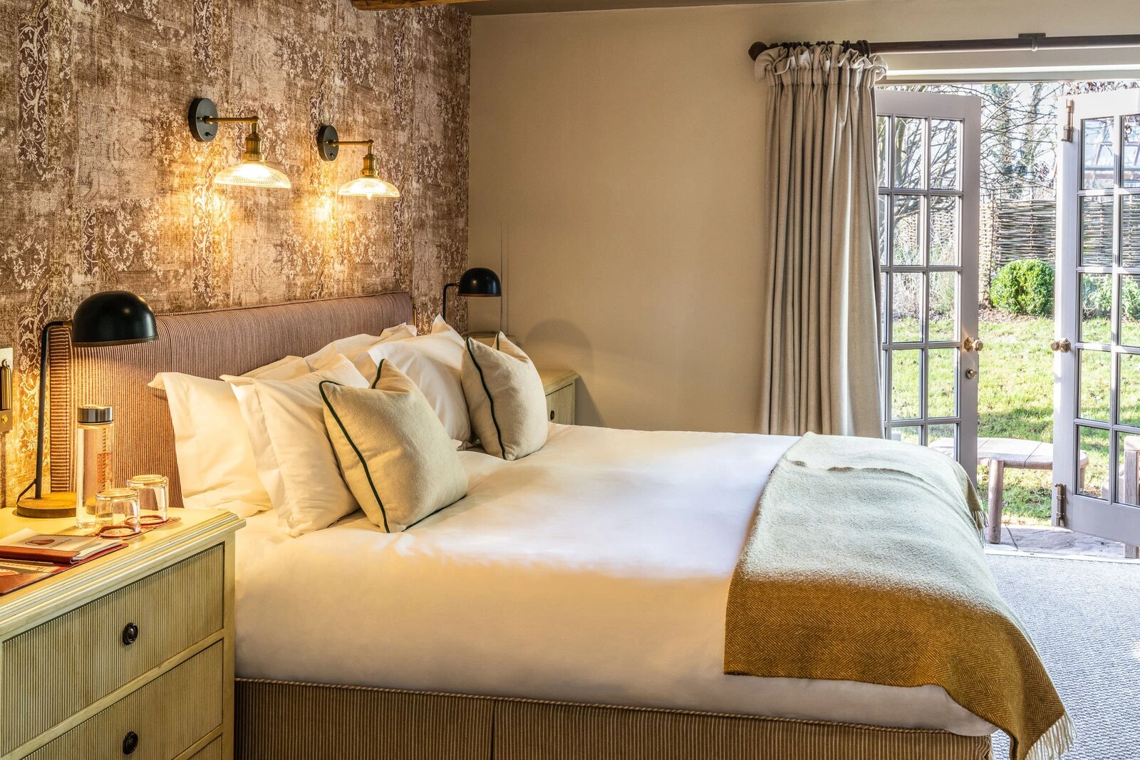 The Double Red Duke — a patterned bedroom opening to the garden through French doors