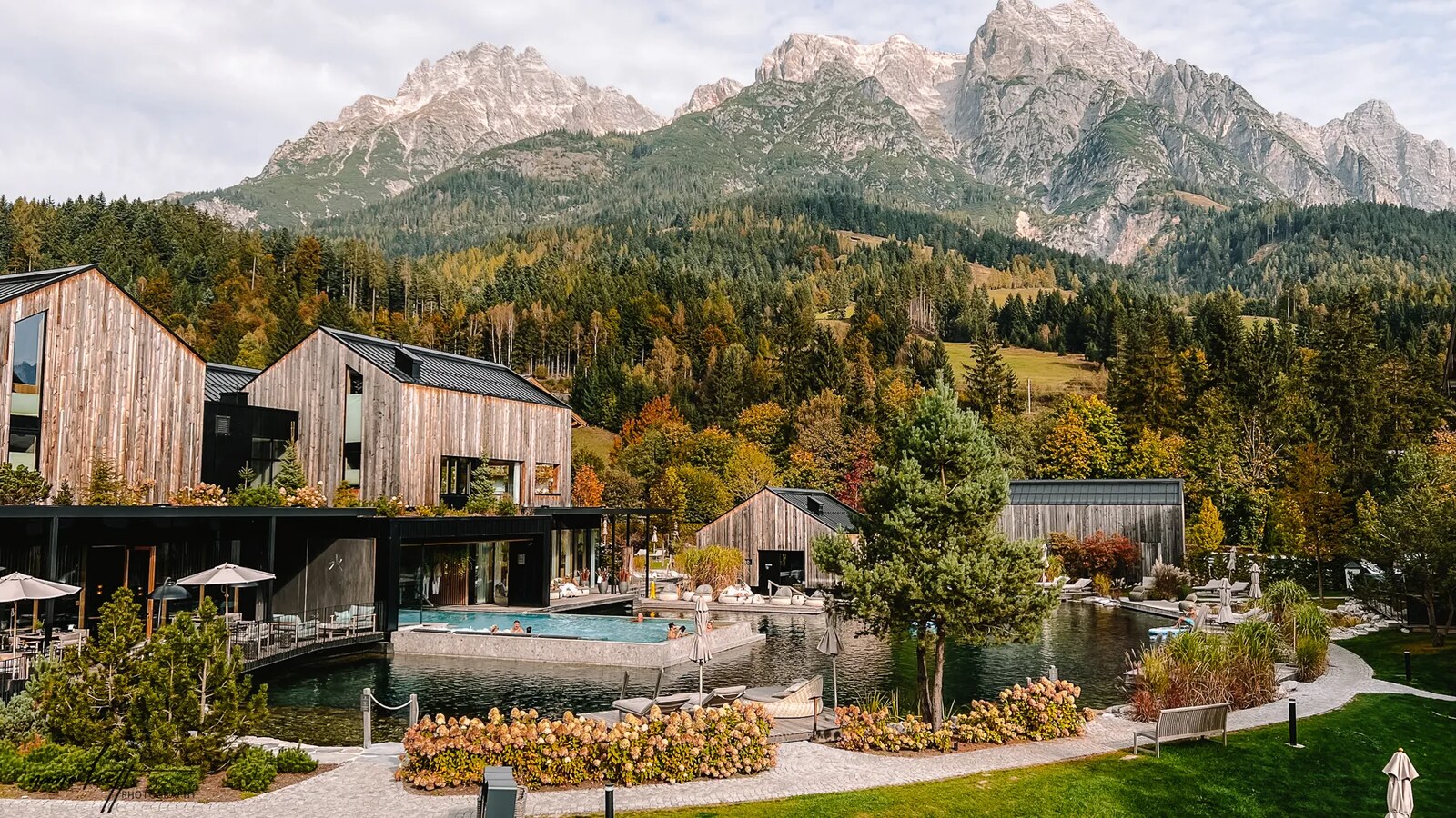 Naturhotel Forsthofgut — the natural bathing lake below the mountains in autumn