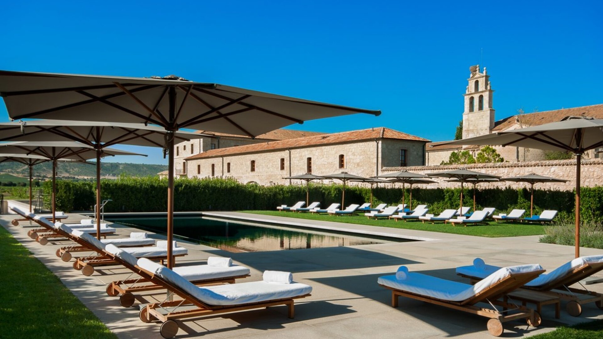 Abad&iacute;a Retuerta &mdash; outdoor pool with the abbey behind
