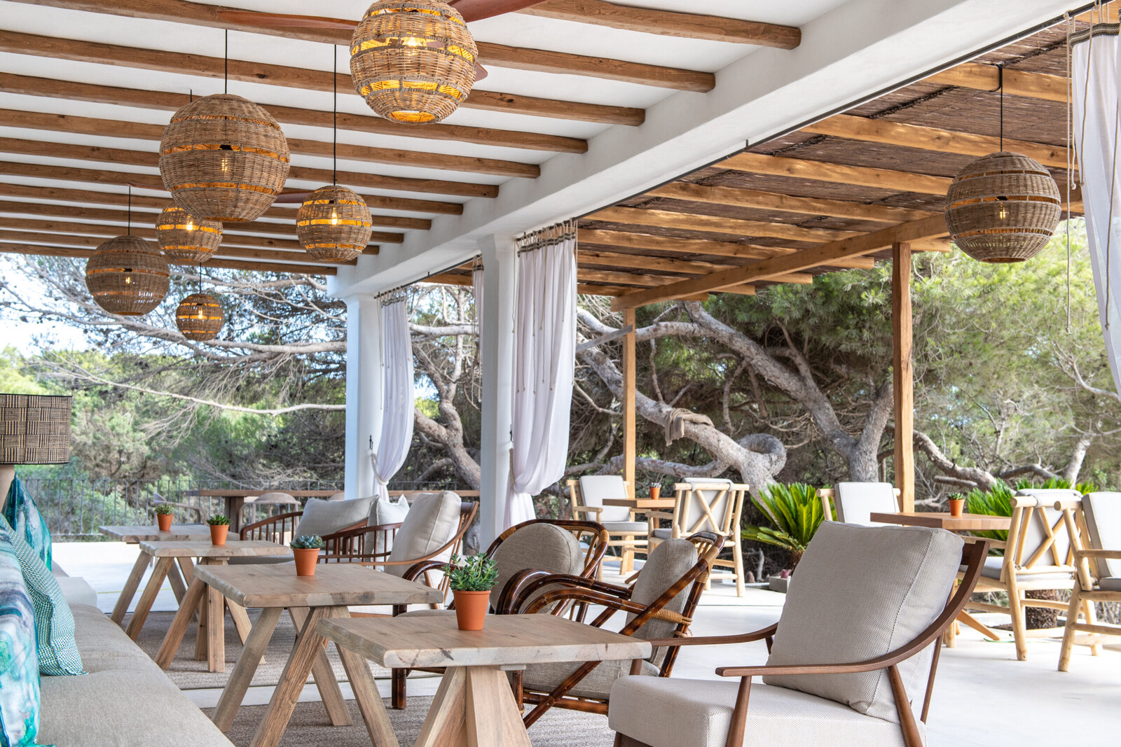 Teranka &mdash; the pergola dining room with woven lanterns and linen curtains