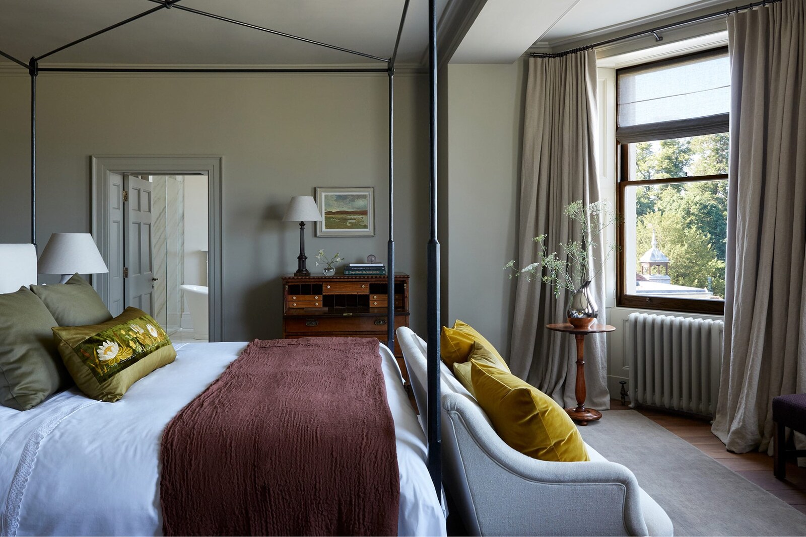 A four-poster lake-view room with a view to the gardens