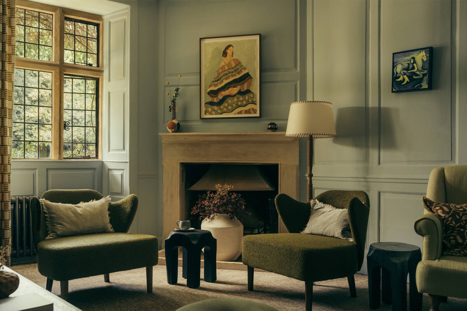HYLL — a panelled sitting room with olive bouclé chairs and a stone fireplace