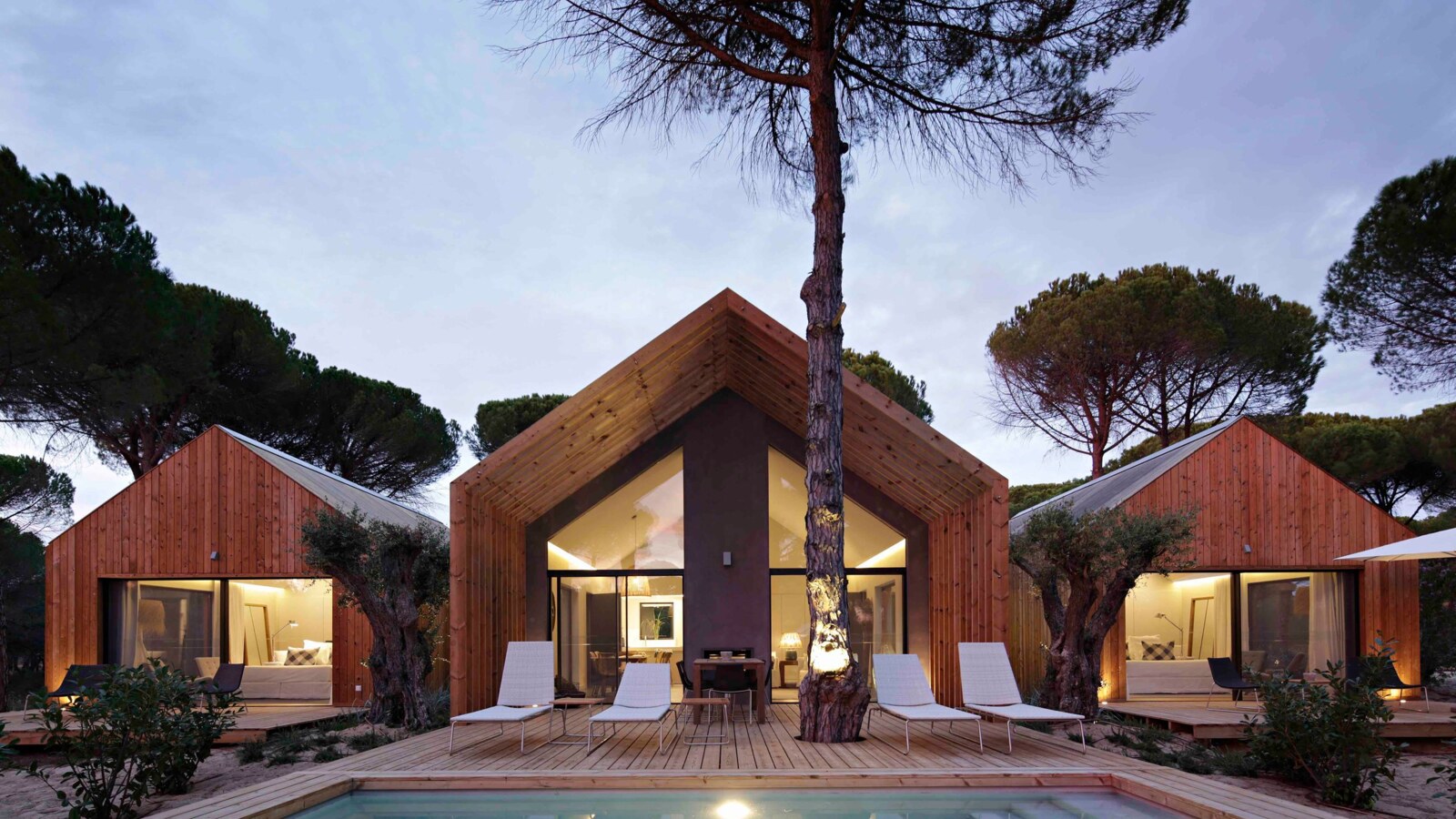 Sublime Comporta &mdash; timber cabanas glowing at dusk above the water