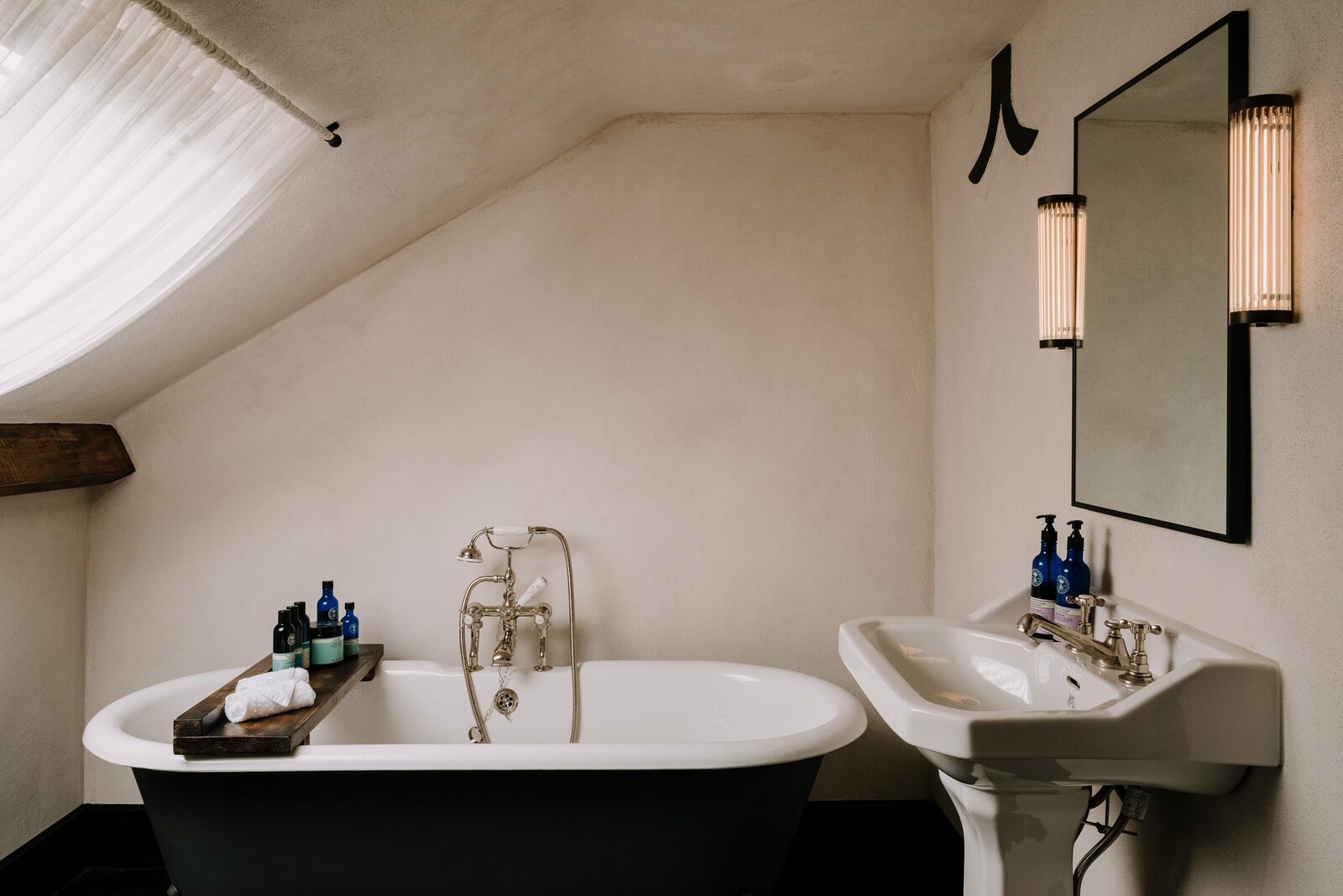The Bull, Charlbury — an attic bathroom with a roll-top bath and pedestal basin