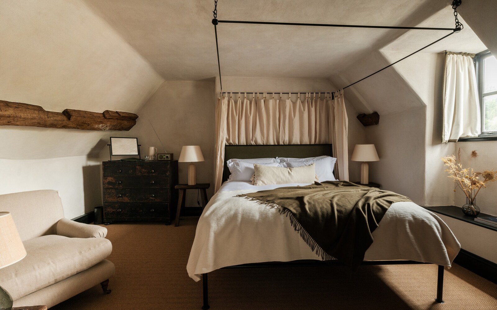 The Bull, Charlbury — a larger bedroom with a canopy bed, armchair and antique chest of drawers
