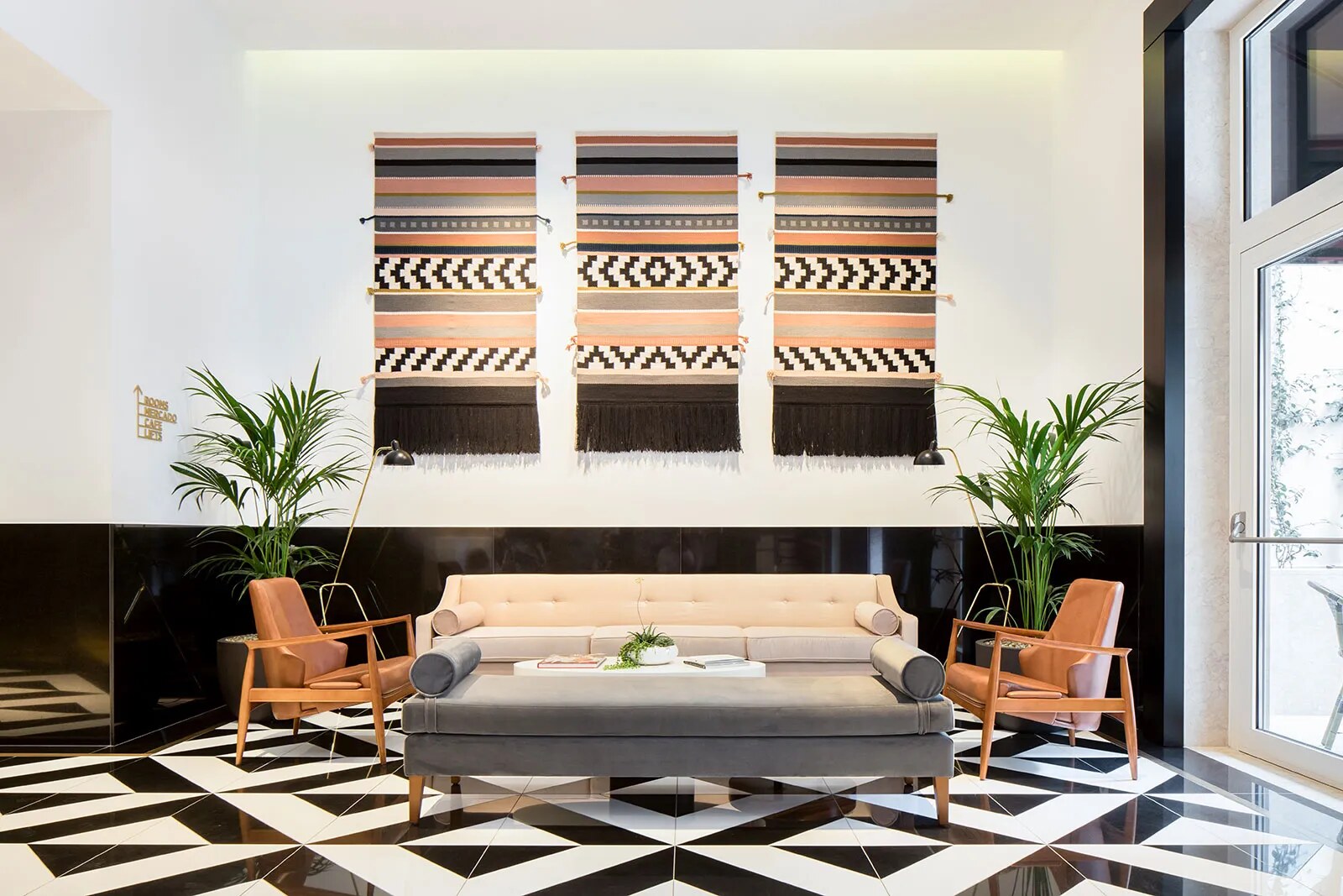 The Lumiares &mdash; a living space over a black-and-white tiled floor, woven art above