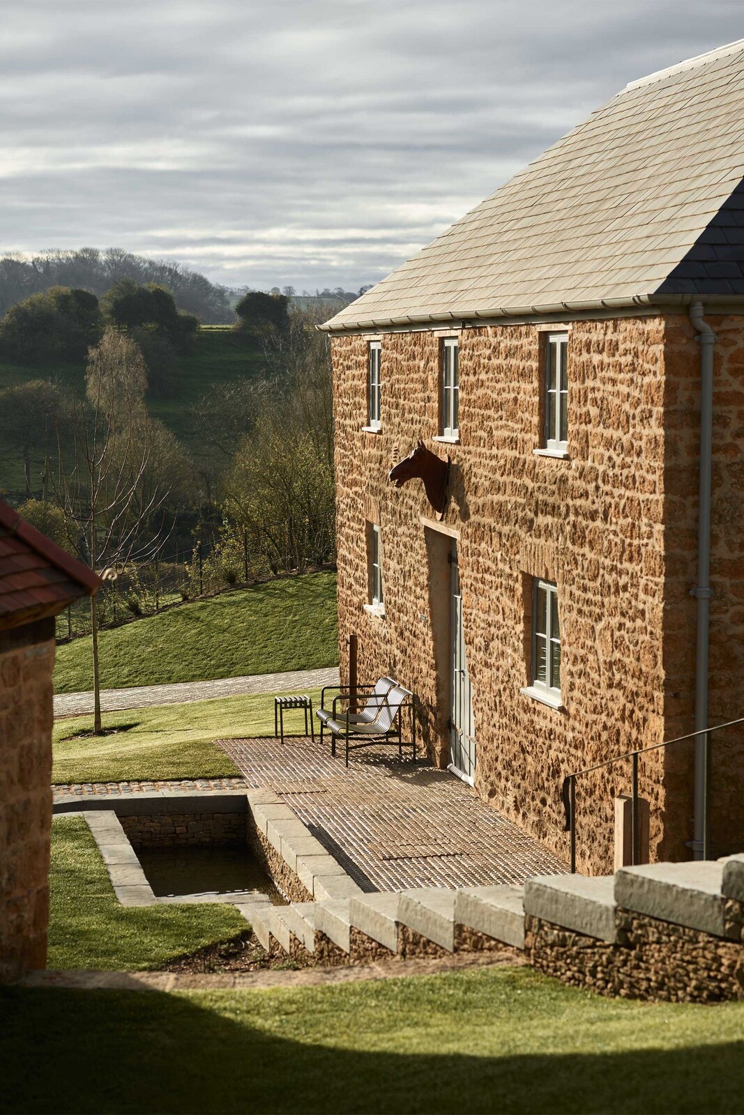 The Newt in Somerset — Somerset-stone farmyard buildings above the hills