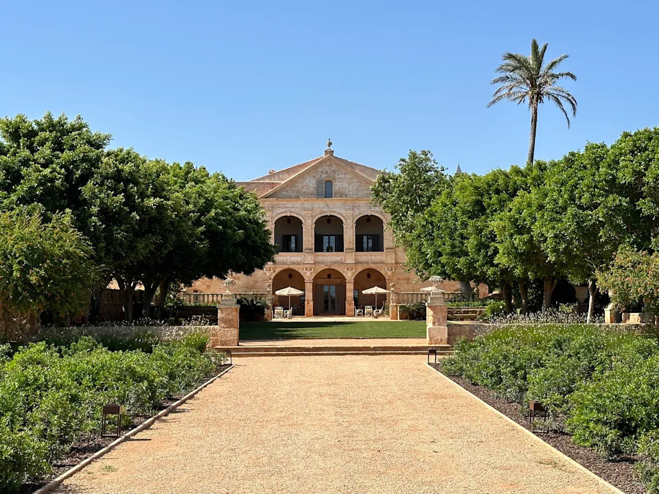 Vestige Son Vell — the arcaded manor façade seen down the formal gardens