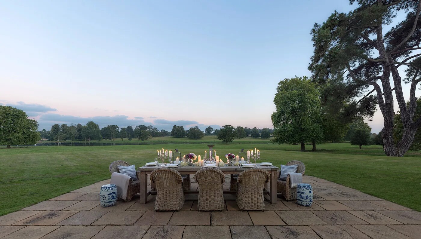 Wilderness Reserve — candlelit dinner table on the lawn at dusk