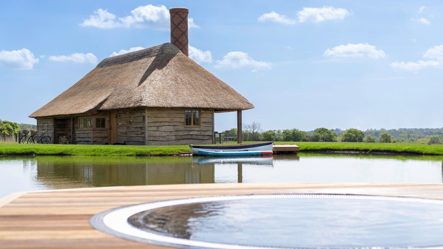 Wilderness Reserve — thatched lakeside cottage with rowing boat